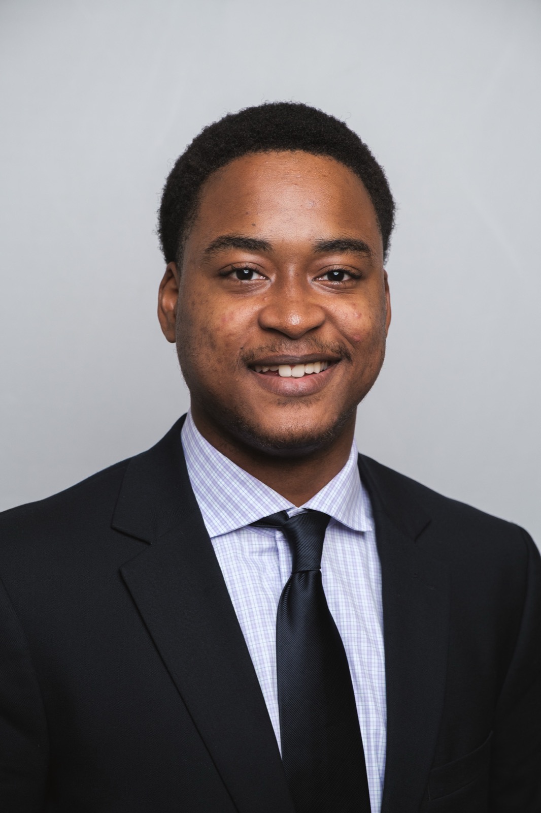 Professional studio headshot, man in suit and tie