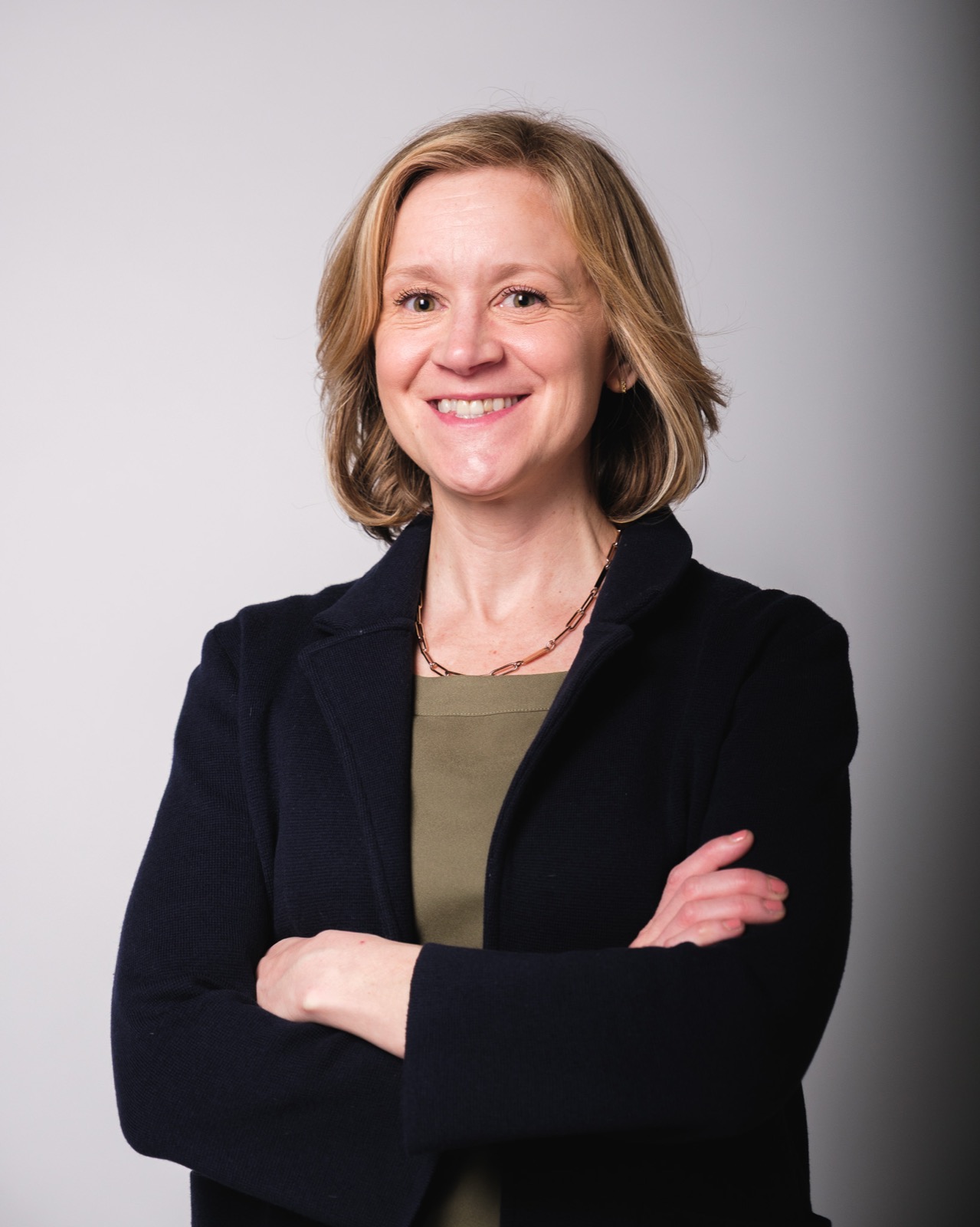 Executive studio headshot, woman in navy blazer