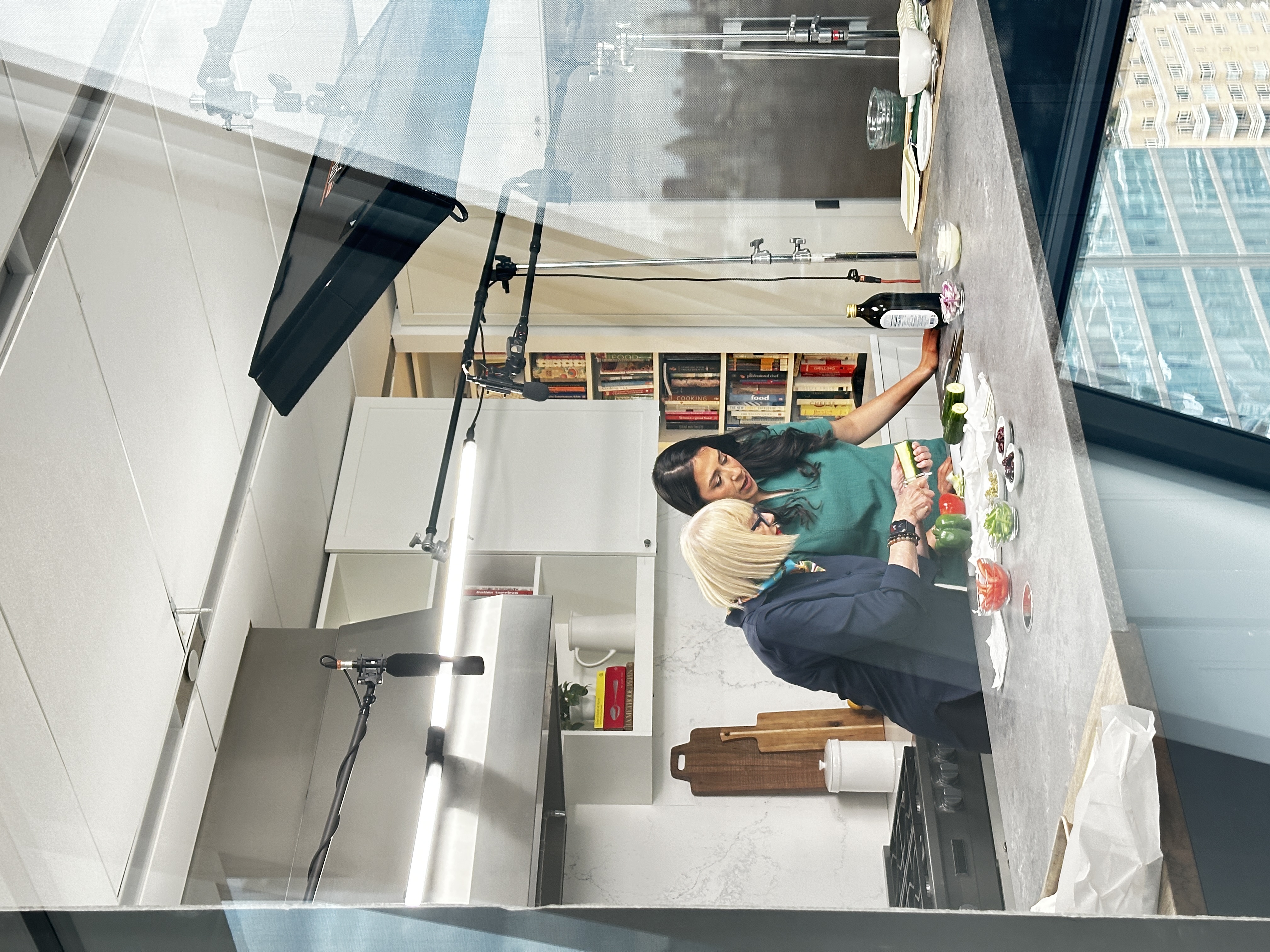 Cooking show production with hosts, boom mic, and teleprompter