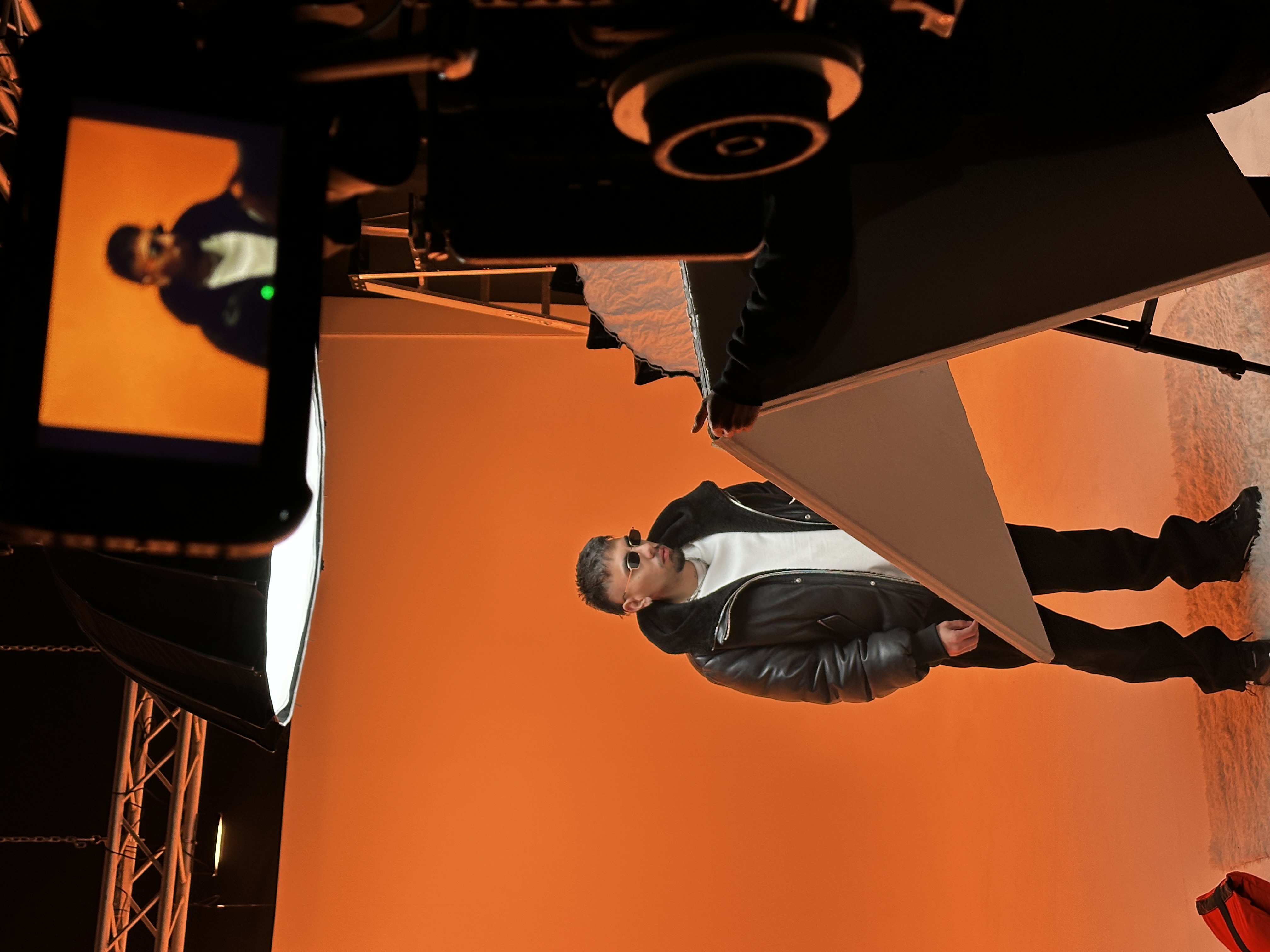 Artist in leather jacket on orange seamless cyc